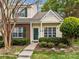 Charming townhome with brick and siding, green door and shutters, and landscaped front yard at 8230 Rudolph Rd, Charlotte, NC 28216