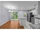 Open kitchen features stainless appliances, granite countertops, white cabinets and sliding glass door to backyard at 8230 Rudolph Rd, Charlotte, NC 28216