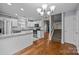 Kitchen with stainless appliances, granite countertops, white cabinets and hardwood floors adjacent to staircase at 8230 Rudolph Rd, Charlotte, NC 28216