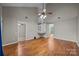 Open living room with hardwood floors, vaulted ceilings, fan, and spiral staircase at 8230 Rudolph Rd, Charlotte, NC 28216