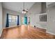 Bright living room with hardwood floors, vaulted ceilings, fan, and blue front door at 8230 Rudolph Rd, Charlotte, NC 28216
