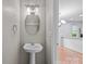 Stylish powder room features a pedestal sink, decorative lighting and hardwood floors at 8230 Rudolph Rd, Charlotte, NC 28216