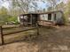 A charming, rustic-style home is showcased with a simple fence and natural landscaping in a tranquil setting at 104 Little River Trl, Fort Mill, SC 29707