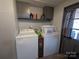 Well-equipped laundry area featuring a washer, dryer, overhead cabinets, and linoleum flooring at 104 Little River Trl, Fort Mill, SC 29707