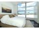 A bright bedroom features a large window and minimalist decor for a tranquil retreat with city views at 1100 Metropolitan Ave # 314, Charlotte, NC 28204
