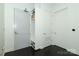 Hallway with a utility closet and coat closet featuring black hardwood floors and white walls at 1100 Metropolitan Ave # 314, Charlotte, NC 28204