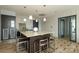 Kitchen with oversized island featuring stone countertop, bar stool seating, and pendant lighting at 1100 Metropolitan Ave # 314, Charlotte, NC 28204