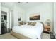 Bright bedroom featuring dark hardwood floors, a large window, and ensuite bathroom for a peaceful retreat at 1100 Metropolitan Ave # 314, Charlotte, NC 28204