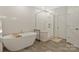 Bright bathroom featuring a modern tub, glass shower, and light wood-look tile floor at 11019 Kilkenny Dr # 41, Charlotte, NC 28277