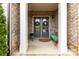 Inviting front door with wreaths, complemented by a cozy bench, sets a welcoming tone to this brick home at 11019 Kilkenny Dr # 41, Charlotte, NC 28277