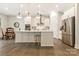 Open kitchen with stainless appliances, white cabinets, island with stool seating, and breakfast nook at 11019 Kilkenny Dr # 41, Charlotte, NC 28277