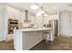 Modern kitchen features stainless steel appliances, white cabinetry, large island with bar seating, and stylish pendant lighting at 11019 Kilkenny Dr # 41, Charlotte, NC 28277