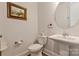 Well-lit powder room with pedestal sink, decorative mirror, and neutral color scheme at 11019 Kilkenny Dr # 41, Charlotte, NC 28277