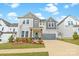 Charming two-story home featuring stone accents, a gray garage door, and manicured landscaping at 11036 Shreveport Dr, Huntersville, NC 28078