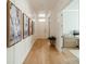 Bright hallway with wood floors, white walls, and decorative art leading to an office space at 11036 Shreveport Dr, Huntersville, NC 28078