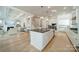 Open kitchen with large island, white cabinets, leading to a living space and staircase at 11036 Shreveport Dr, Huntersville, NC 28078