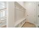 Bright mudroom with built-in bench, storage shelves, coat hooks, and a door to the outside at 11036 Shreveport Dr, Huntersville, NC 28078