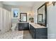 This bathroom features dual sinks, black cabinets, and black and white tile floors at 114 Ventana Ct, Mooresville, NC 28117