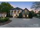 Stunning two-story home with stone accents, elegant arches, manicured landscaping, and spacious driveway at 114 Ventana Ct, Mooresville, NC 28117
