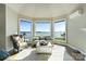 This light-filled sitting area features bay windows with peaceful water views and comfortable seating at 114 Ventana Ct, Mooresville, NC 28117