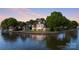 Picturesque waterfront home featuring a stone patio, gazebo, lush greenery, and serene water views at 114 Ventana Ct, Mooresville, NC 28117