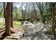 Backyard fire pit area with stone pathway and surrounding natural landscape at 11901 Rock Canyon Dr, Charlotte, NC 28226