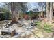 Backyard stone patio with fire pit and house with deck in background at 11901 Rock Canyon Dr, Charlotte, NC 28226