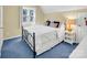 Cozy bedroom featuring a black metal bed frame, blue carpet, and natural light from the window at 11901 Rock Canyon Dr, Charlotte, NC 28226