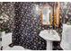 Stylish half bath with patterned wallpaper, pedestal sink, and decorative mirrors at 11901 Rock Canyon Dr, Charlotte, NC 28226