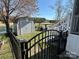 Tranquil backyard featuring a storage shed, gazebo with patio furniture, bordered by a black metal fence near the lake at 134 Putt Putt Ln, New London, NC 28127
