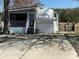 Well-kept mobile home with a covered porch, set on a concrete pad with an iron gate at 134 Putt Putt Ln, New London, NC 28127
