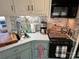 Kitchen features vintage cabinets, a black microwave, modern appliances, a stainless steel sink, and good natural light at 134 Putt Putt Ln, New London, NC 28127