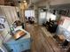 Open kitchen and living area with white cabinets, wood floors, and sheer curtains at 134 Putt Putt Ln, New London, NC 28127