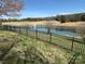 Picturesque lake view with fountain, bordered by a black metal fence, and natural scenery for a peaceful environment at 134 Putt Putt Ln, New London, NC 28127