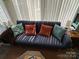 Sunlit living room featuring a comfortable blue sofa with colorful pillows and sheer curtains at 134 Putt Putt Ln, New London, NC 28127