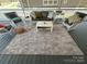 Inviting outdoor patio with wicker furniture, comfortable cushions, and a neutral rug at 134 Putt Putt Ln, New London, NC 28127