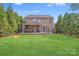 Spacious backyard with a well-maintained lawn, a cozy patio area, and lush landscaping for outdoor relaxation at 1504 Ridge Haven Rd, Waxhaw, NC 28173