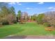 Expansive backyard featuring a lush lawn, mature trees, and a charming firepit area for outdoor entertainment at 1504 Ridge Haven Rd, Waxhaw, NC 28173