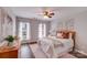 Sun-filled bedroom with hardwood floors, a ceiling fan, art piece, and two windows at 1504 Ridge Haven Rd, Waxhaw, NC 28173
