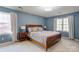 Primary bedroom with blue walls, two windows, and hardwood furniture at 1537 Wheaton Nw Way, Concord, NC 28027