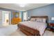 Bright primary bedroom with wooden dresser, mirror, and natural light at 1537 Wheaton Nw Way, Concord, NC 28027