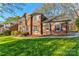Charming two-story brick home with a lush green lawn and mature trees, creating a welcoming curb appeal at 1537 Wheaton Nw Way, Concord, NC 28027