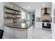 Well-lit kitchen with a breakfast bar, floating shelves, and stainless steel appliances at 1537 Wheaton Nw Way, Concord, NC 28027