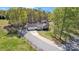 Aerial view of a charming home with a long driveway, mature trees, and a lush green lawn at 1584 Beverly Ln, Lincolnton, NC 28092