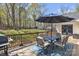 Back deck features a table with seating for six, an umbrella, and a beautiful green, partially wooded backyard at 1584 Beverly Ln, Lincolnton, NC 28092
