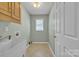 This laundry room features a utility sink, overhead cabinets, and plenty of natural light at 1584 Beverly Ln, Lincolnton, NC 28092