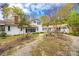 Expansive backyard with mature trees, a stone picnic table, and a charming white house at 165 Mimosa Ter, Wadesboro, NC 28170