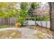 Landscaped backyard features a wooden pergola, blooming redbud tree, and privacy fence at 165 Mimosa Ter, Wadesboro, NC 28170