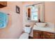 Cozy bathroom with pink walls featuring a pedestal sink, toilet, and decorative mirror at 165 Mimosa Ter, Wadesboro, NC 28170