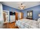 Comfortable bedroom with hardwood floors, a ceiling fan, blue walls, and furniture at 165 Mimosa Ter, Wadesboro, NC 28170